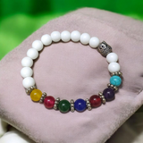 7 Chakra Bracelet featuring colorful healing stones and white Howlite beads, stretchable and lab-certified for spiritual balance