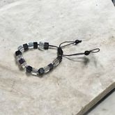 A beautiful black and white crystal bracelet designed for attraction, energy balance, and healing, displayed on a neutral background