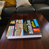 A book titled Sampurna Vastu Shastra & Dosh Nivaran in Hindi with a large font, placed on a desk with a peaceful and harmonious background symbolizing positive energy flow