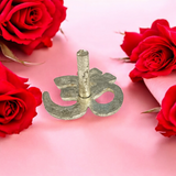 A close-up image of the Om Tilak Sancha, a brass stamp used for applying sacred Om tilak on the forehead during worship rituals and religious ceremonies.