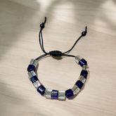 A soothing blue and white crystal bracelet for energy balance, attraction, and emotional healing, displayed neatly with soft lighting
