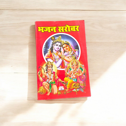 Bhajan Book in Hindi with colorful cover featuring Hindu deities and text mentioning 200+ bhajans and 15+ aartis