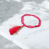 Close-up image of a lab-certified Red Coral Mala with 4MM beads and 108+1 bead count, perfect for chanting and meditation