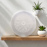Engraved selenite crystal charging plate with zodiac signs, used for cleansing and recharging crystals, meditation, pooja, and spiritual home décor