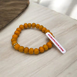 Haldi Bracelet made of 8MM natural turmeric beads, stretchable design, and certificate of authenticity for spiritual and healing benefits.