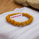 Haldi Bracelet made of 8MM natural turmeric beads, stretchable design, and certificate of authenticity for spiritual and healing benefits.
