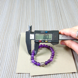 Natural Amethyst Bracelet with polished purple beads, stretchable design, placed on a neutral background