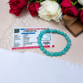 Natural Blue Chalcedony Bracelet made with 8mm smooth round stretchable beads, lab certified, placed on a natural stone background