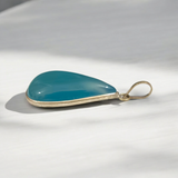 Original Firoza pendant with a vibrant turquoise hue, displayed on a necklace, highlighting its polished finish and elegant design.