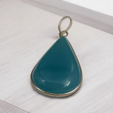 Original Firoza pendant with a vibrant turquoise hue, displayed on a necklace, highlighting its polished finish and elegant design.