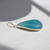 Original Firoza pendant with a vibrant turquoise hue, displayed on a necklace, highlighting its polished finish and elegant design.