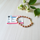 Rudraksha and Moti (Pearl) Bracelet with elegant design, stretchable, placed on a spiritual fabric background