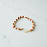 Rudraksha and Moti (Pearl) Bracelet with elegant design, stretchable, placed on a spiritual fabric background