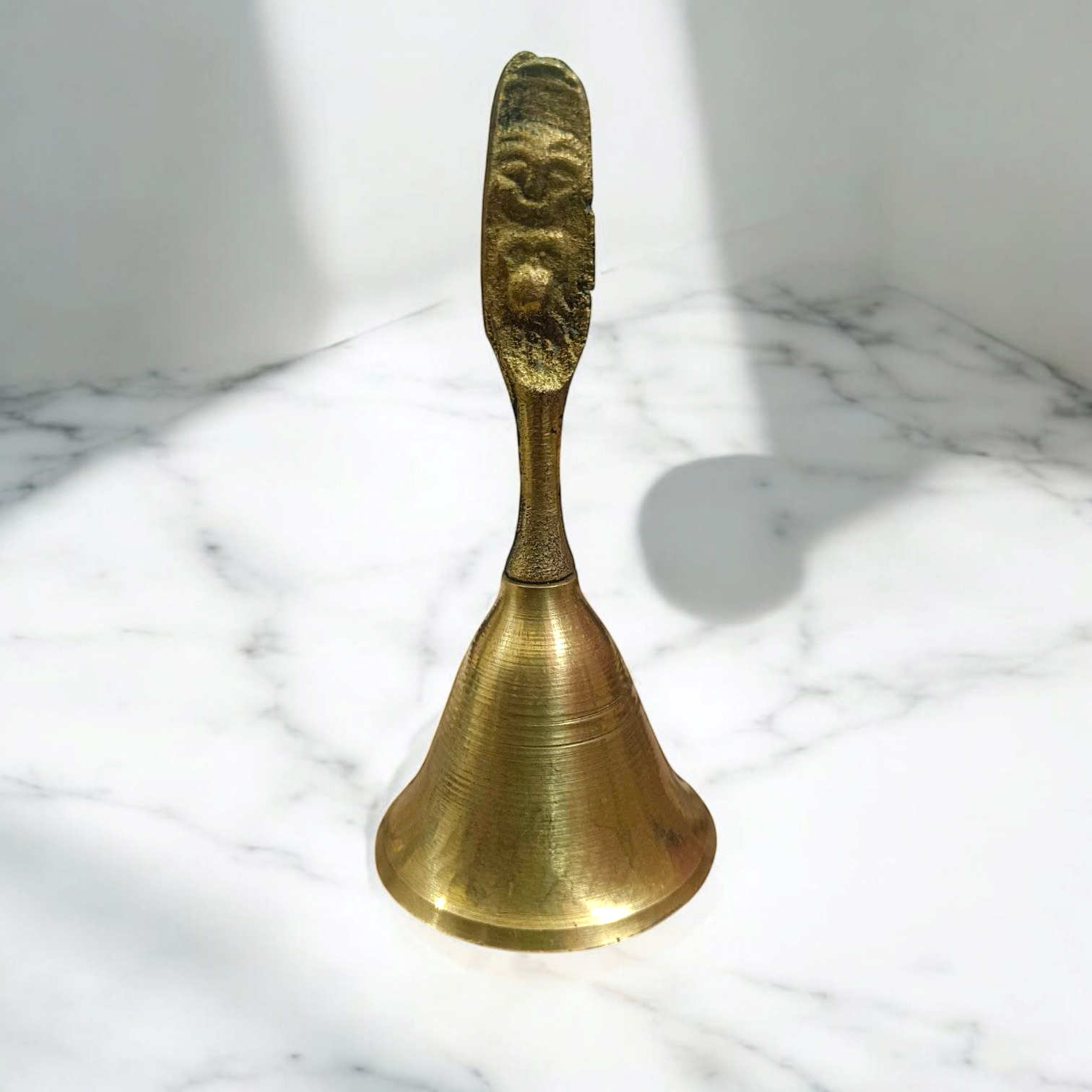 A 7cm Bajarng Balli Brass Hand Bell, crafted from pure brass, ideal for religious rituals, enhancing spiritual ambiance and inviting positive energy.
