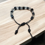 A beautiful black and white crystal bracelet designed for attraction, energy balance, and healing, displayed on a neutral background