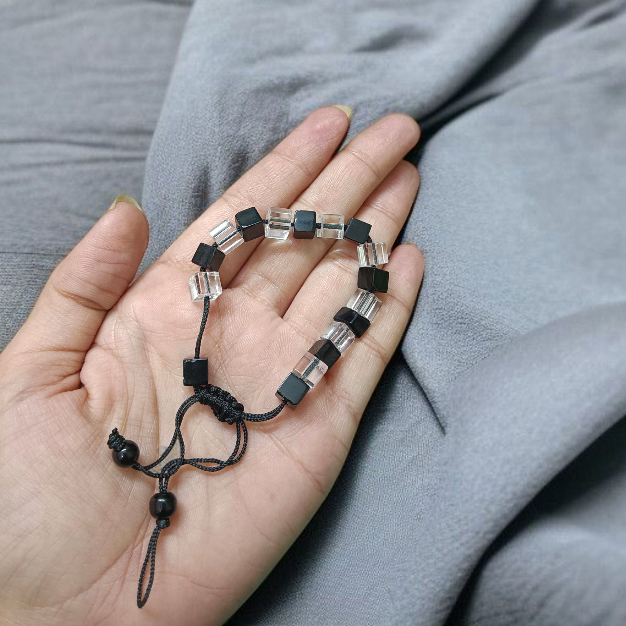 A beautiful black and white crystal bracelet designed for attraction, energy balance, and healing, displayed on a neutral background