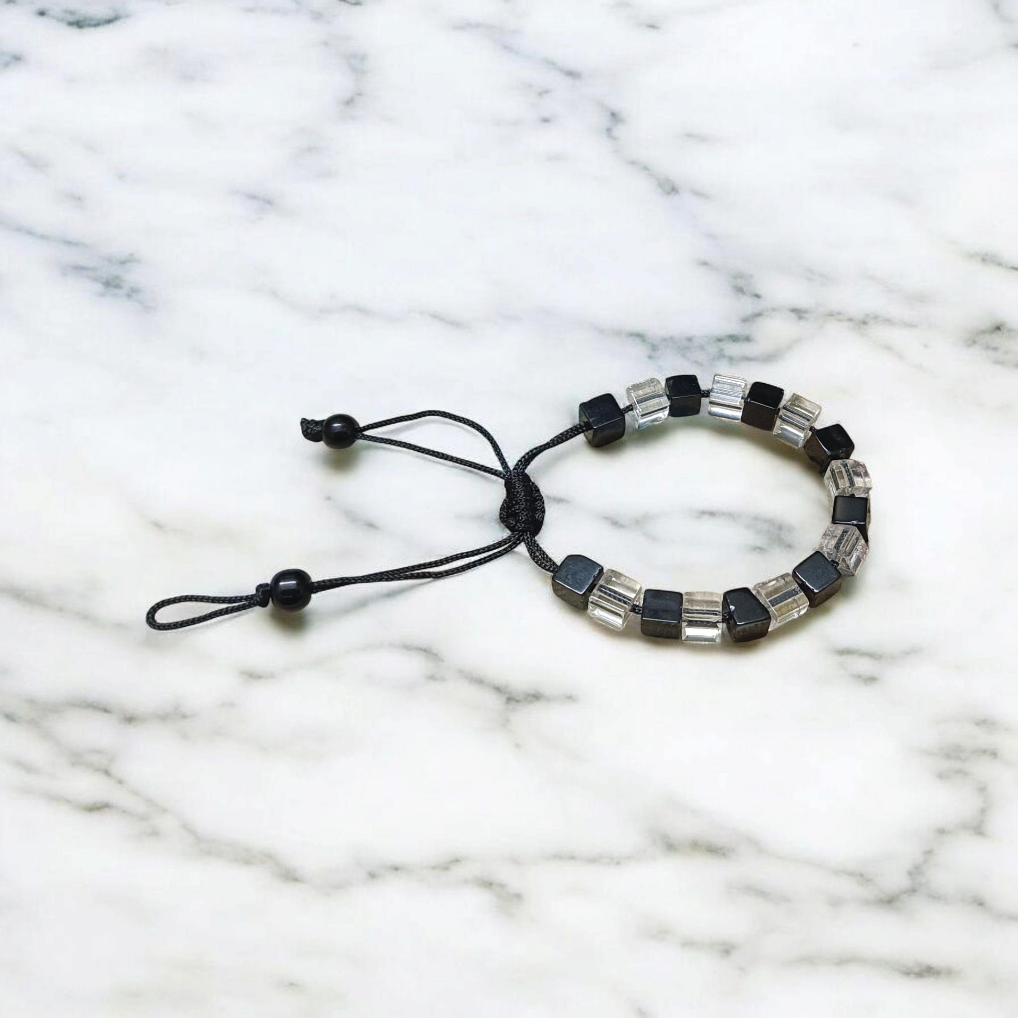 A beautiful black and white crystal bracelet designed for attraction, energy balance, and healing, displayed on a neutral background