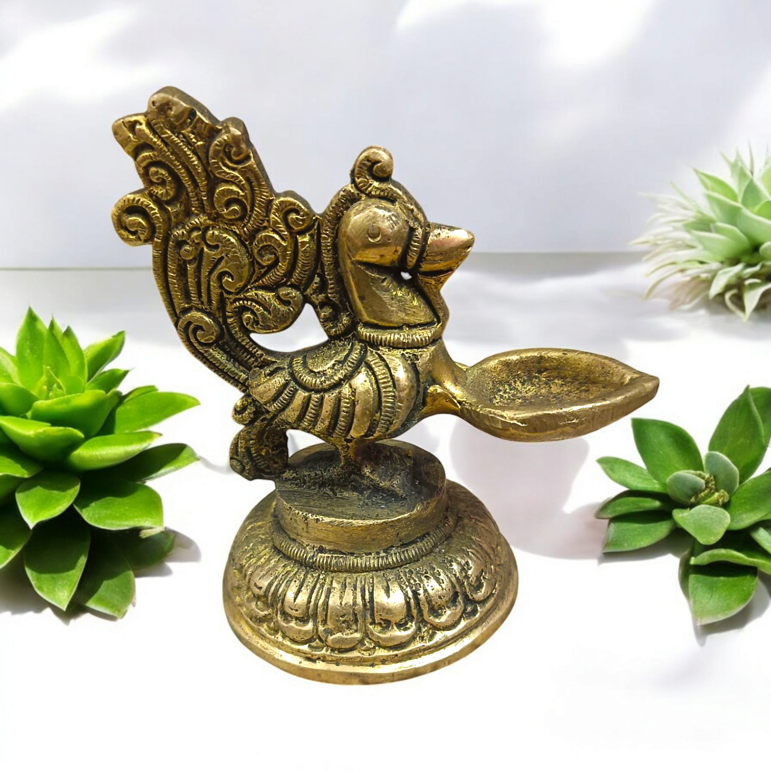 A beautifully crafted Peacock Brass Jyot with Nakshi peacock design, ideal for use in pooja rooms and spiritual spaces.