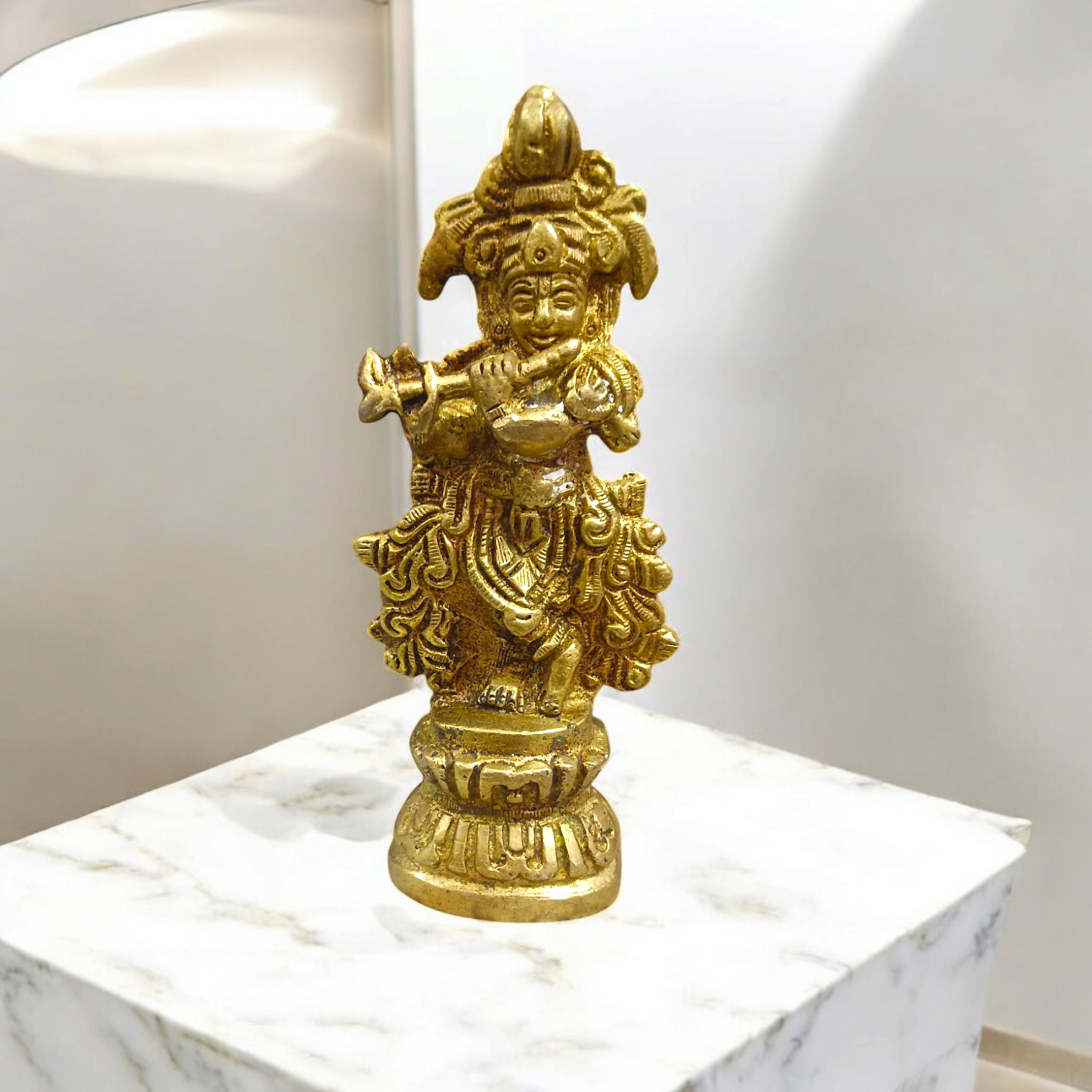 A beautifully crafted brass idol of Lord Krishna, depicting him playing the flute, perfect for worship and home decoration.