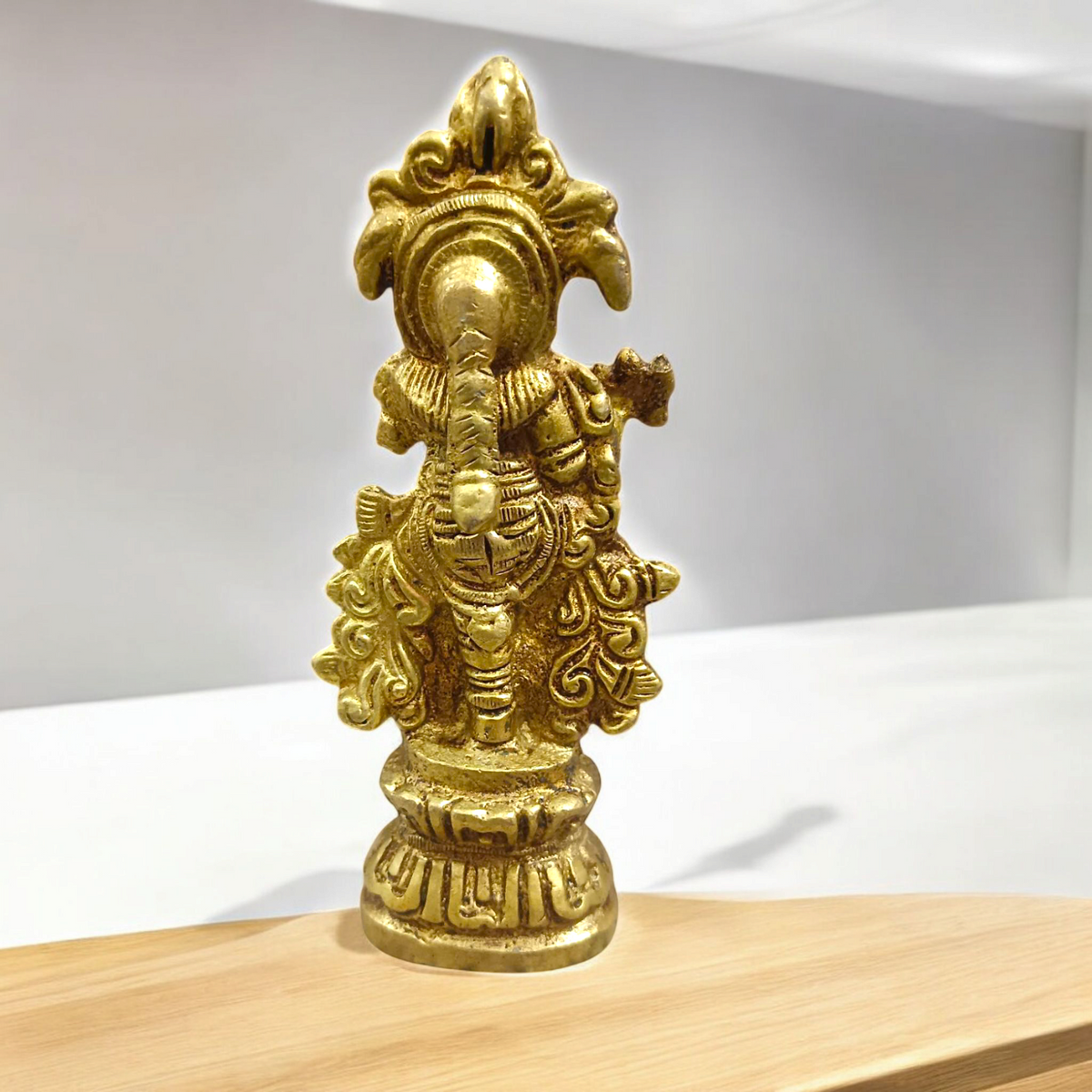 A beautifully crafted brass idol of Lord Krishna, depicting him playing the flute, perfect for worship and home decoration.