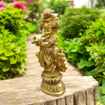 A beautifully crafted brass idol of Lord Krishna, depicting him playing the flute, perfect for worship and home decoration.