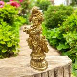 A beautifully crafted brass idol of Lord Krishna, depicting him playing the flute, perfect for worship and home decoration.