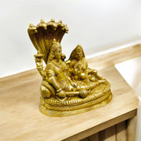 A beautifully crafted brass statue of Lord Lakshmi Narayan resting upon the Shesha Naag, symbolizing wealth, protection, and divine blessings.