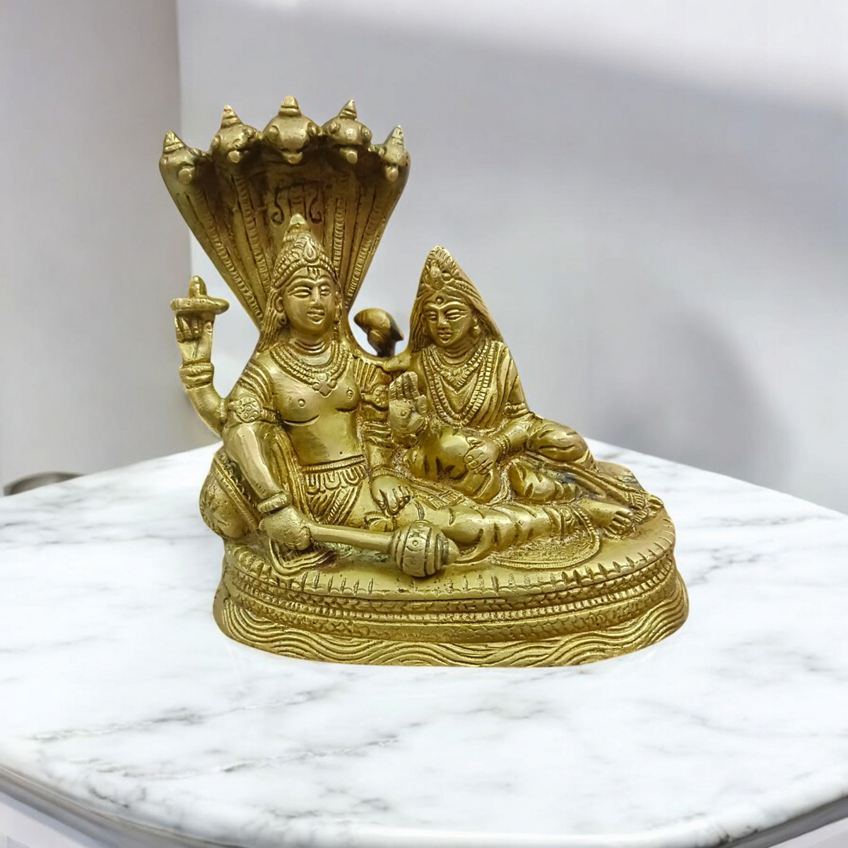 A beautifully crafted brass statue of Lord Lakshmi Narayan resting upon the Shesha Naag, symbolizing wealth, protection, and divine blessings.
