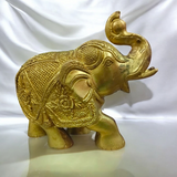 A beautifully crafted large brass elephant statue with an intricate design, symbolizing strength, prosperity, and good fortune, placed on an office table.

