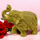 A beautifully crafted large brass elephant statue with an intricate design, symbolizing strength, prosperity, and good fortune, placed on an office table.

