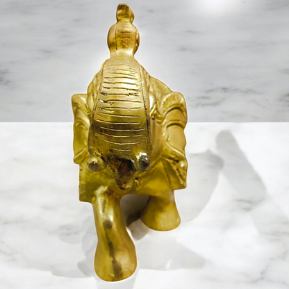 A beautifully crafted large brass elephant statue with an intricate design, symbolizing strength, prosperity, and good fortune, placed on an office table.

