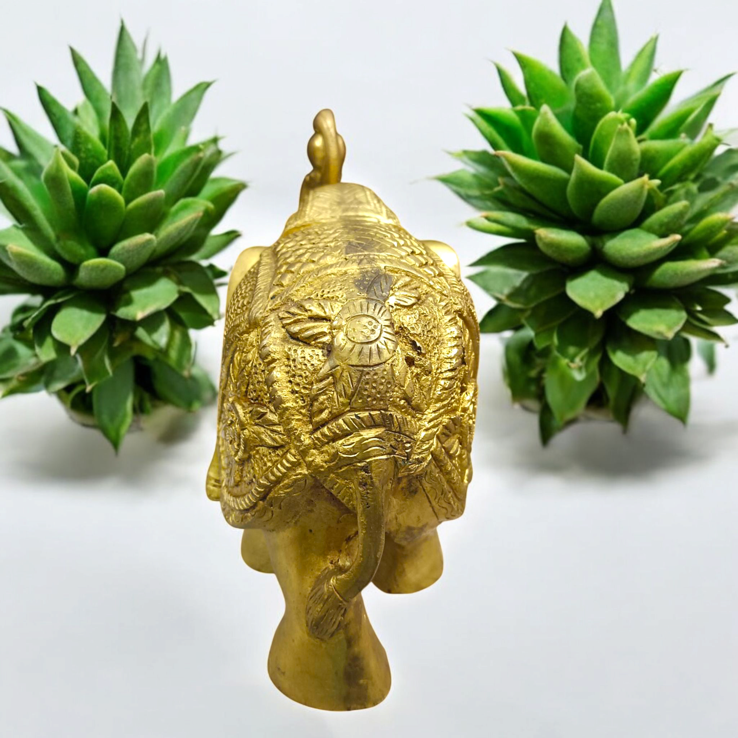 A beautifully crafted large brass elephant statue with an intricate design, symbolizing strength, prosperity, and good fortune, placed on an office table.

