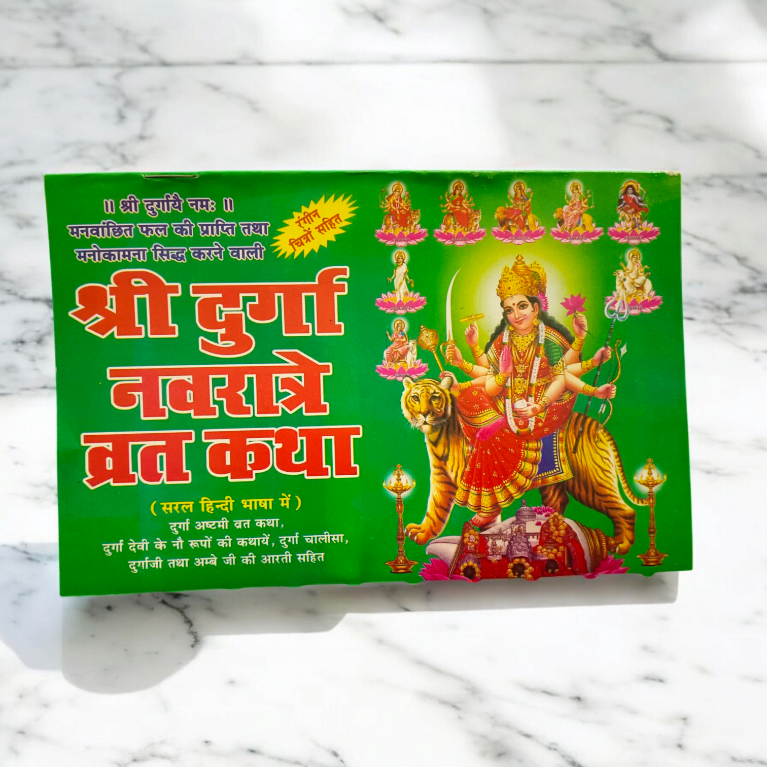 A beautifully designed Navratri Varat Katha book, with vibrant artwork of Goddess Durga, surrounded by flowers and lights, symbolizing the festive atmosphere of Navratri