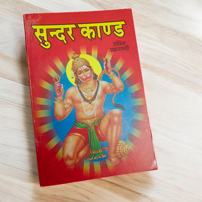 A beautifully designed Sunder Kand Book in Hindi, with big red font, open to a page of the devotional prayers and praises of Lord Hanuman Ji.