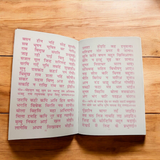 A beautifully designed Sunder Kand Book in Hindi, with big red font, open to a page of the devotional prayers and praises of Lord Hanuman Ji.