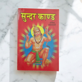 A beautifully designed Sunder Kand Book in Hindi, with big red font, open to a page of the devotional prayers and praises of Lord Hanuman Ji.