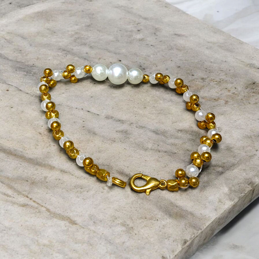 A beautifully handcrafted white and golden pearl designer bracelet, stretchable and elegant—perfect for girls, women, and festive occasions