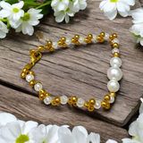A beautifully handcrafted white and golden pearl designer bracelet, stretchable and elegant—perfect for girls, women, and festive occasions