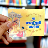 A book titled "Baglamukhi Chalisa" in Hindi with a picture of Maa Baglamukhi’s idol, placed on a divine altar with flowers and incense.