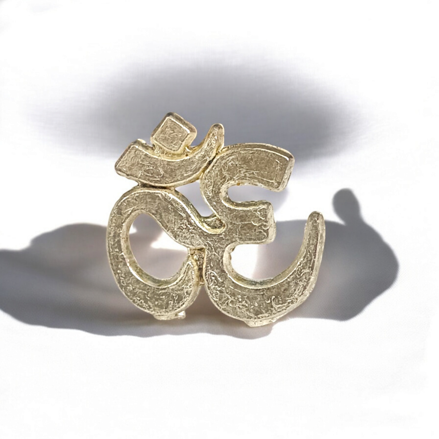 A close-up image of the Om Tilak Sancha, a brass stamp used for applying sacred Om tilak on the forehead during worship rituals and religious ceremonies.