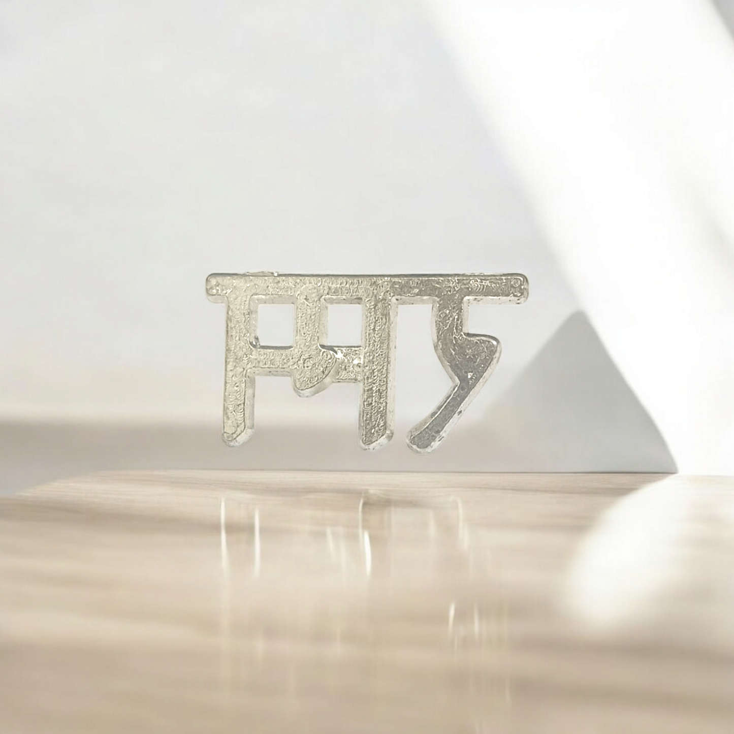 A close-up image of the Ram Tilak Thappa, a brass stamp used for applying sacred tilak on the forehead during religious rituals and worship.
