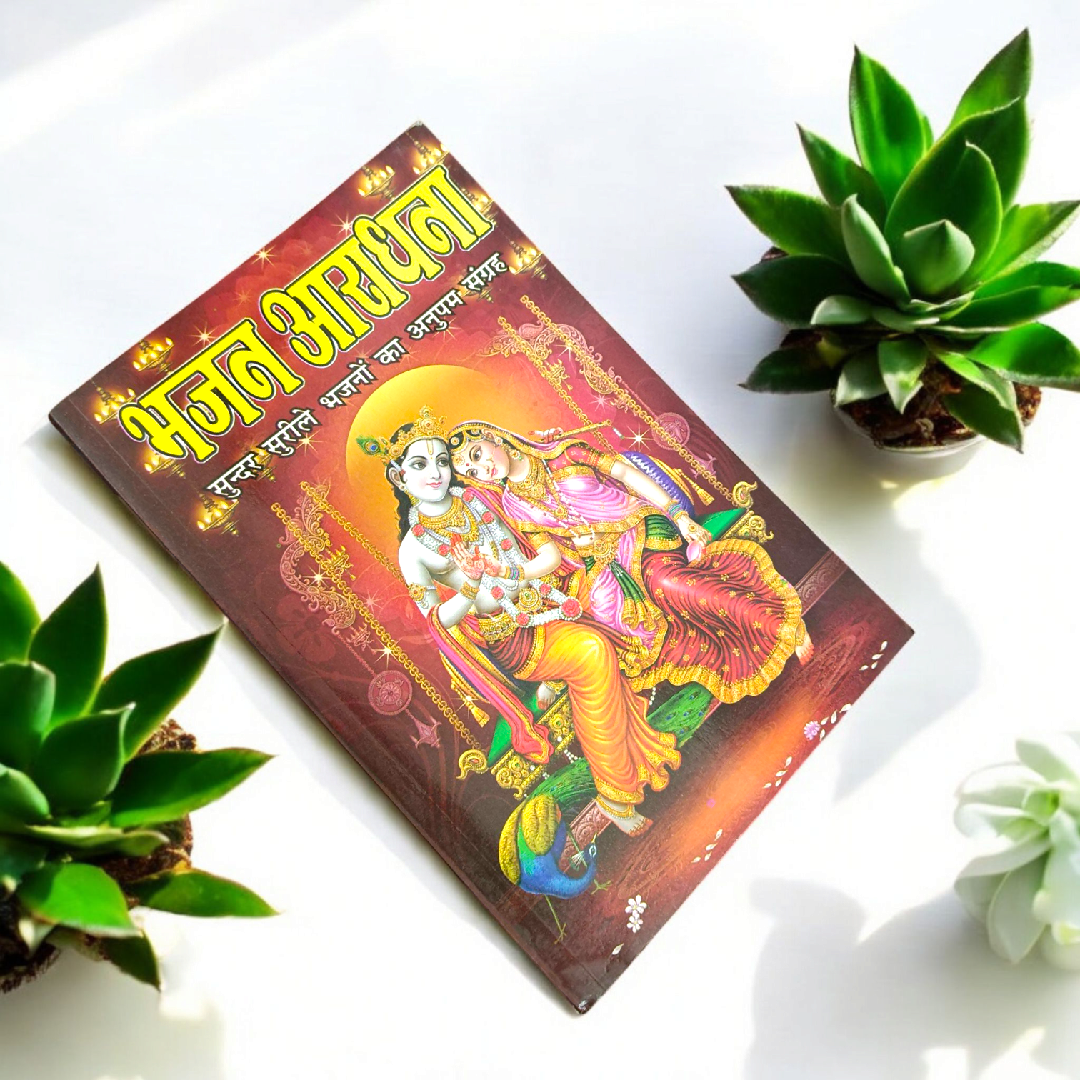 A close-up of a Bhajan Book In Hindi featuring 200+ bhajans and 15+ aartis, with a peaceful spiritual background.