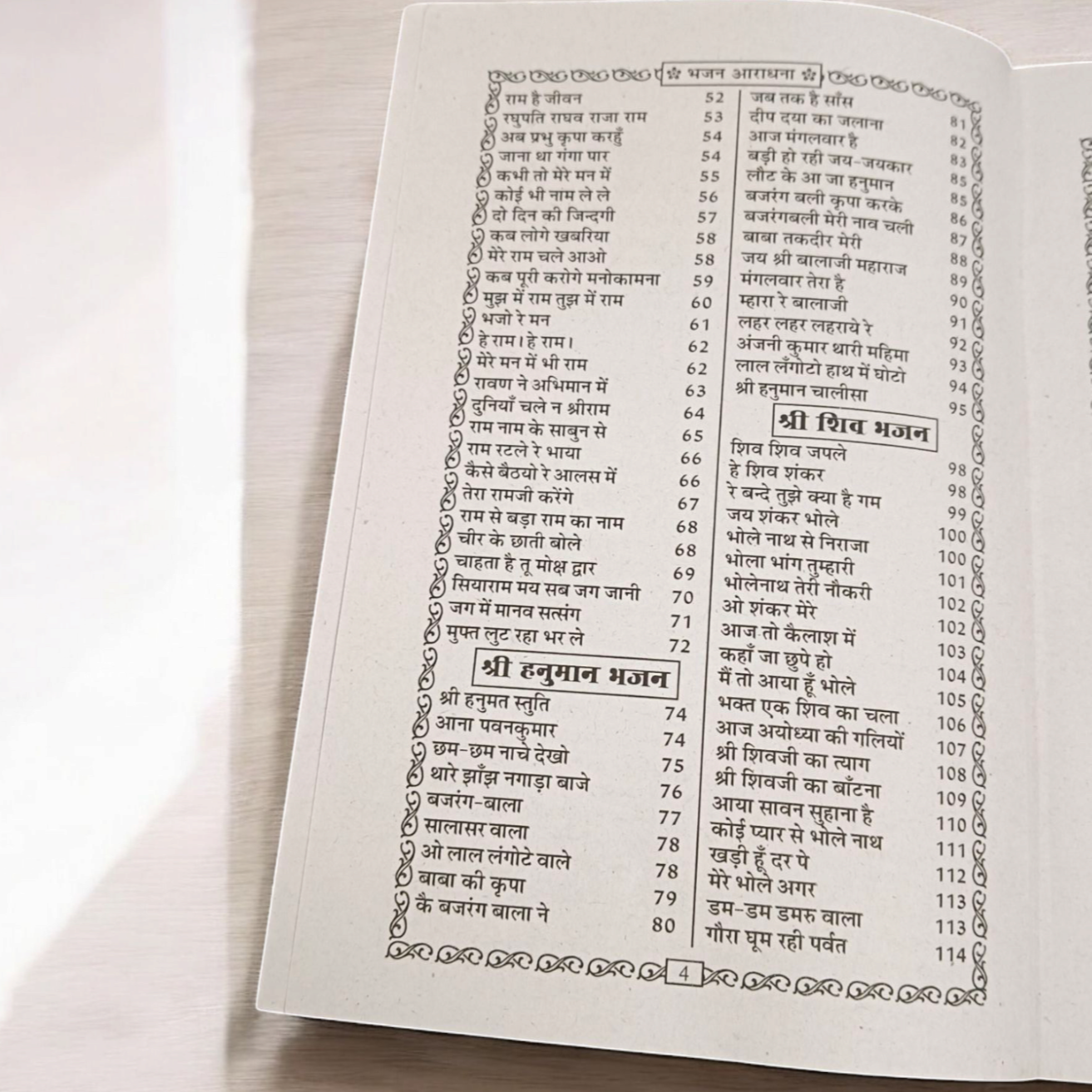 A close-up of a Bhajan Book In Hindi featuring 200+ bhajans and 15+ aartis, with a peaceful spiritual background.