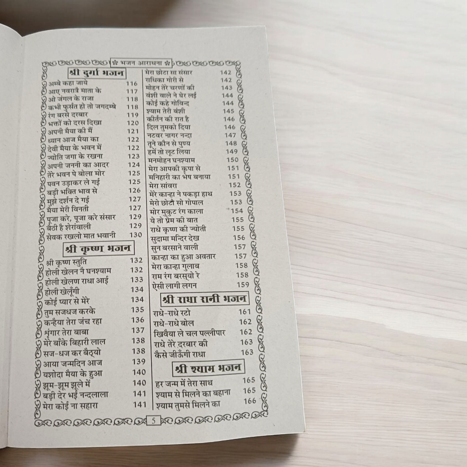 A close-up of a Bhajan Book In Hindi featuring 200+ bhajans and 15+ aartis, with a peaceful spiritual background.