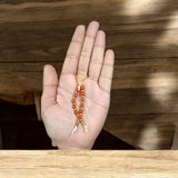 A close-up view of a Rudraksha mala garland, made of small beads, designed for adorning the idol of Laddu Gopal, symbolizing devotion and spiritual connection.