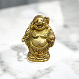 A detailed and polished brass statue of the Laughing Buddha in a standing pose, symbolizing good luck, prosperity, and happiness.