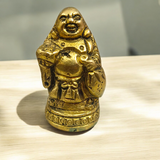 A detailed and polished brass statue of the Laughing Buddha in a standing pose, symbolizing good luck, prosperity, and happiness.