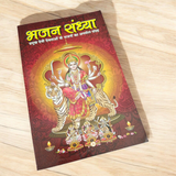 A person holding a Bhajan Book In Hindi featuring devotional bhajans and aartis, with a serene background of a temple.