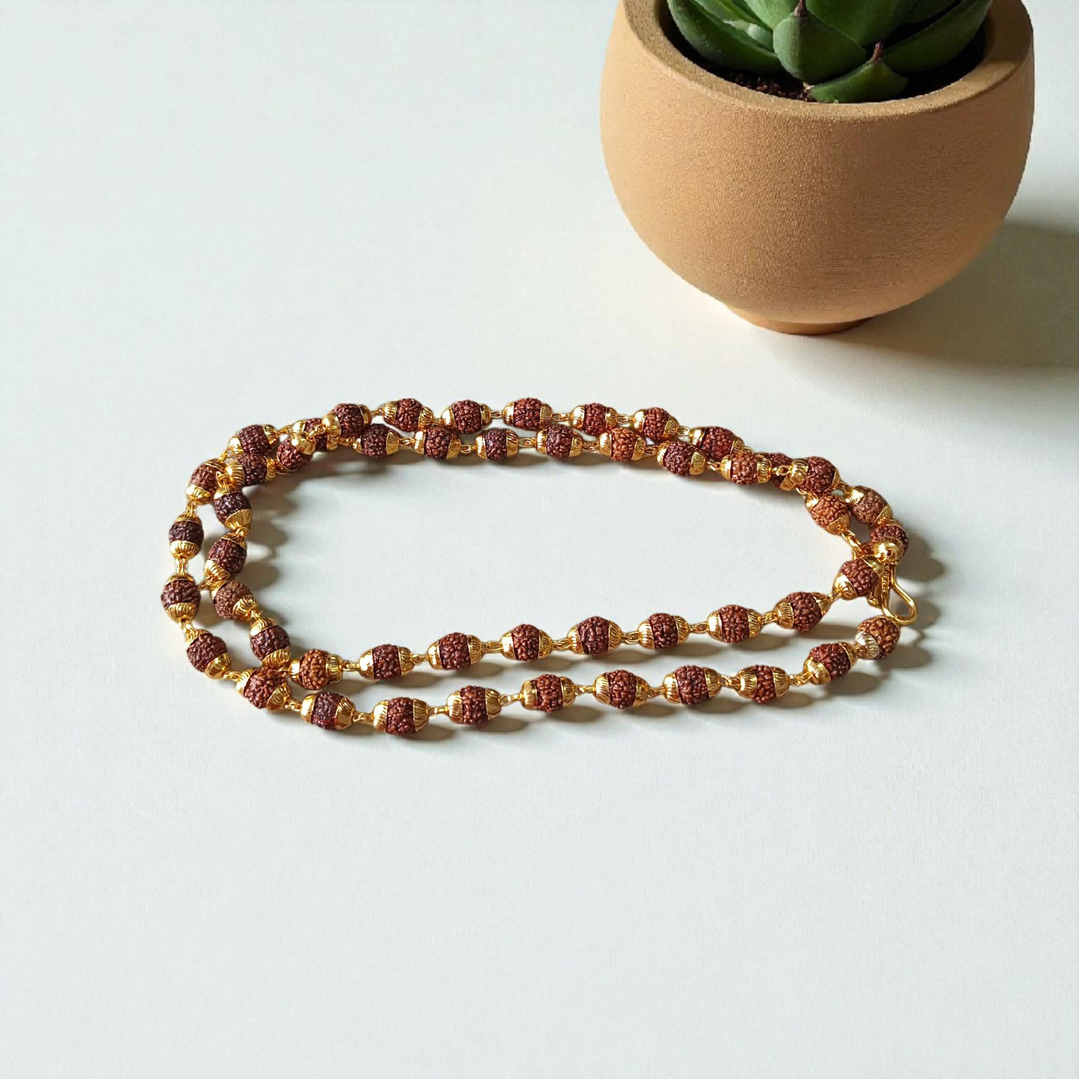 A premium Natural 5 Face Rudraksha Mala with 50 lab-certified 6mm Rudraksha beads, golden caps, and a 1-year golden plating guarantee, symbolizing peace and divine energy