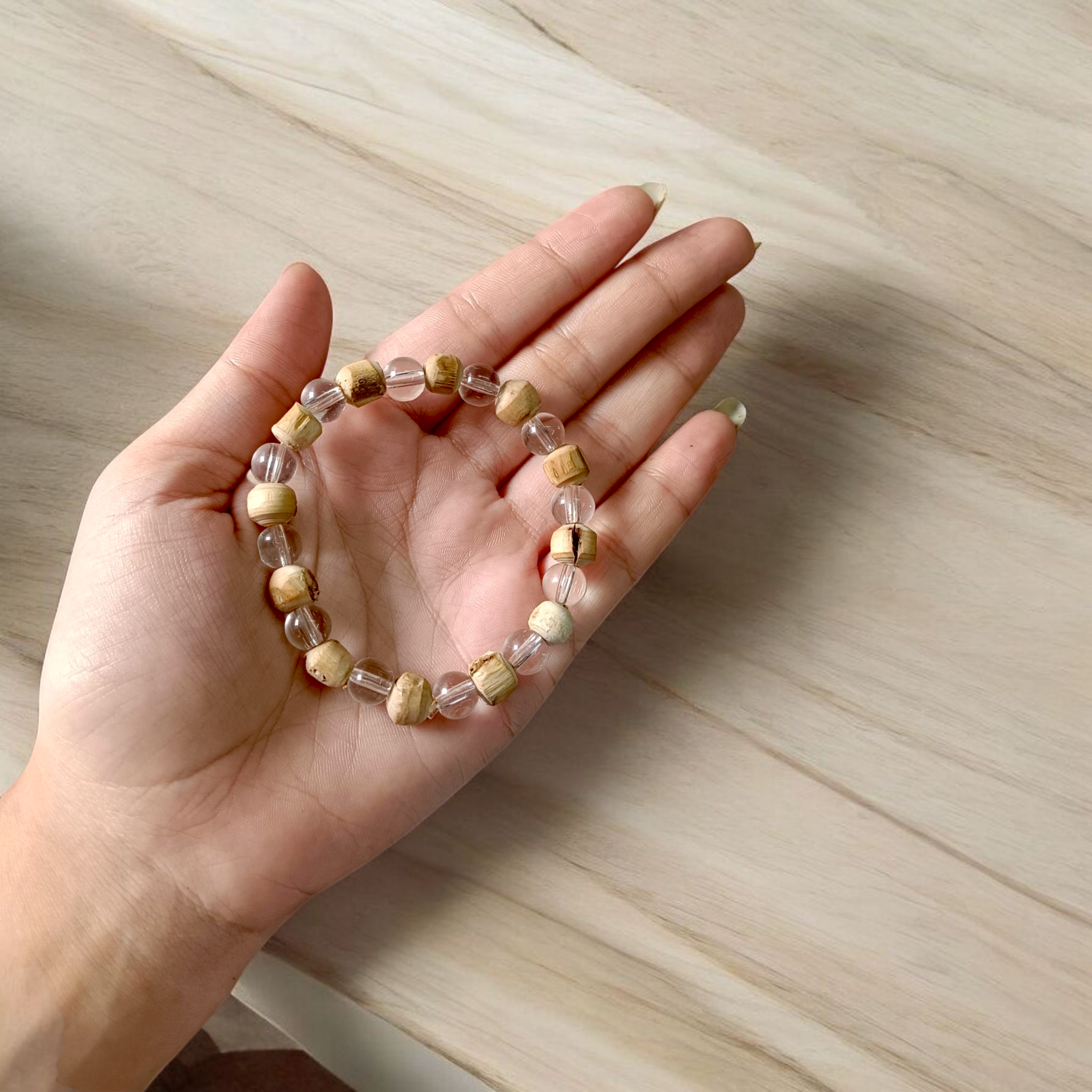 A stretchable 8mm beaded bracelet made from natural Tulsi and Sphatik crystals, ideal for spiritual and healing use, placed against a white background